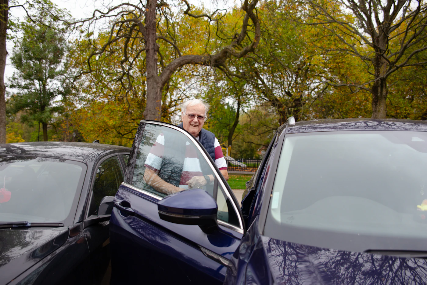 A driver's door open as an elderly man prepares to be driven to his appointment